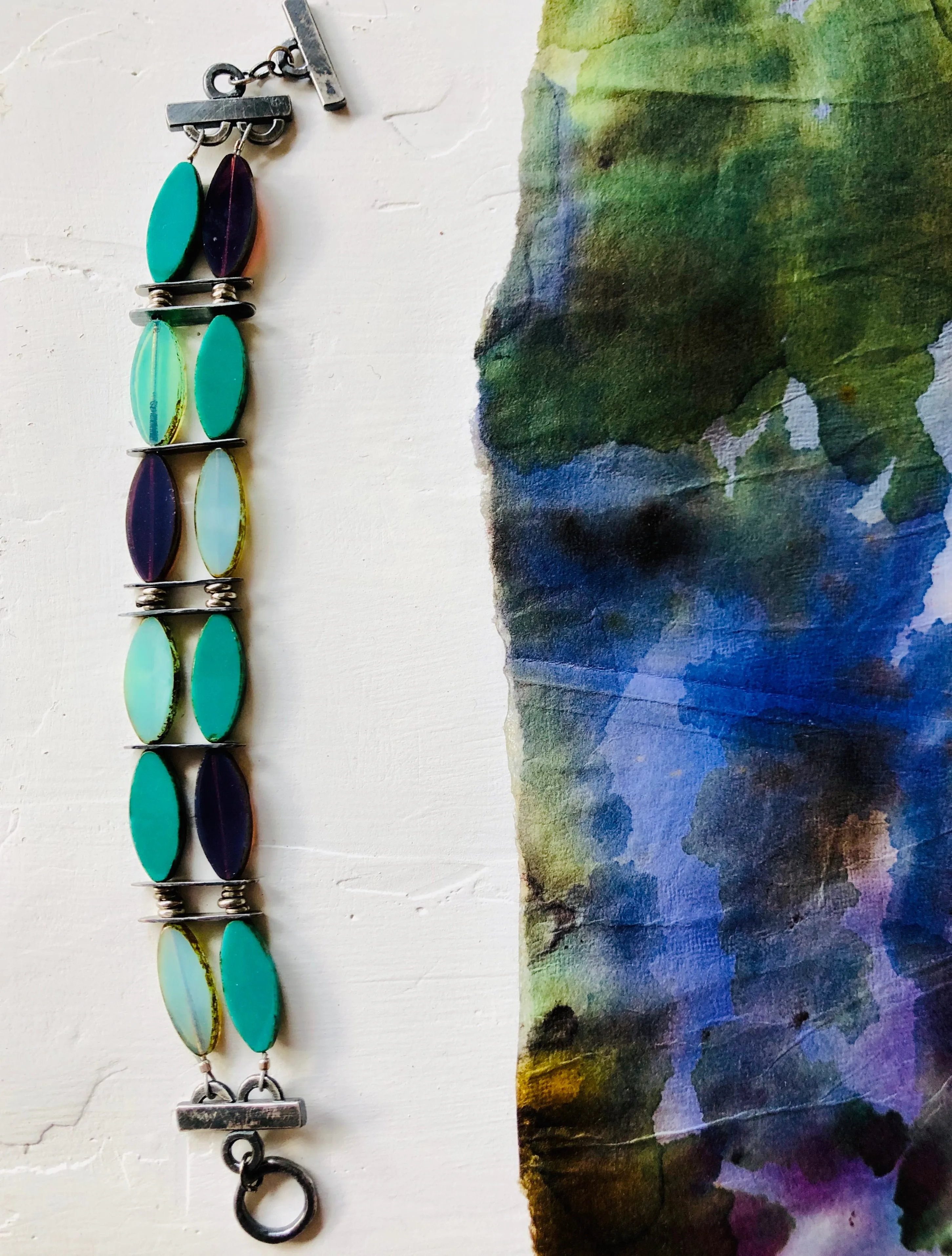 Vintage inspired glass beads accented by hand crafted silver bracelet