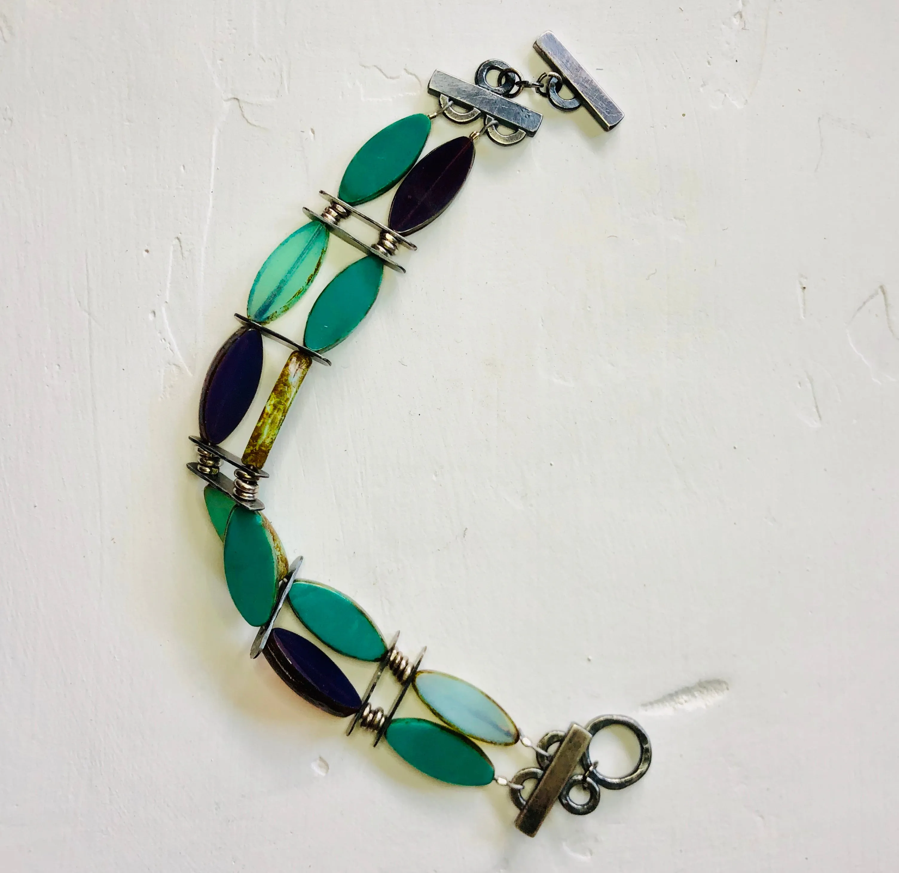 Vintage inspired glass beads accented by hand crafted silver bracelet